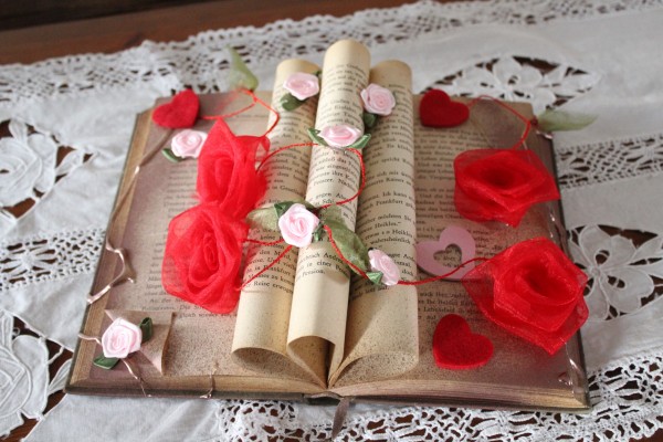 Blumen Dekoration auf altem Buch rote Rosen